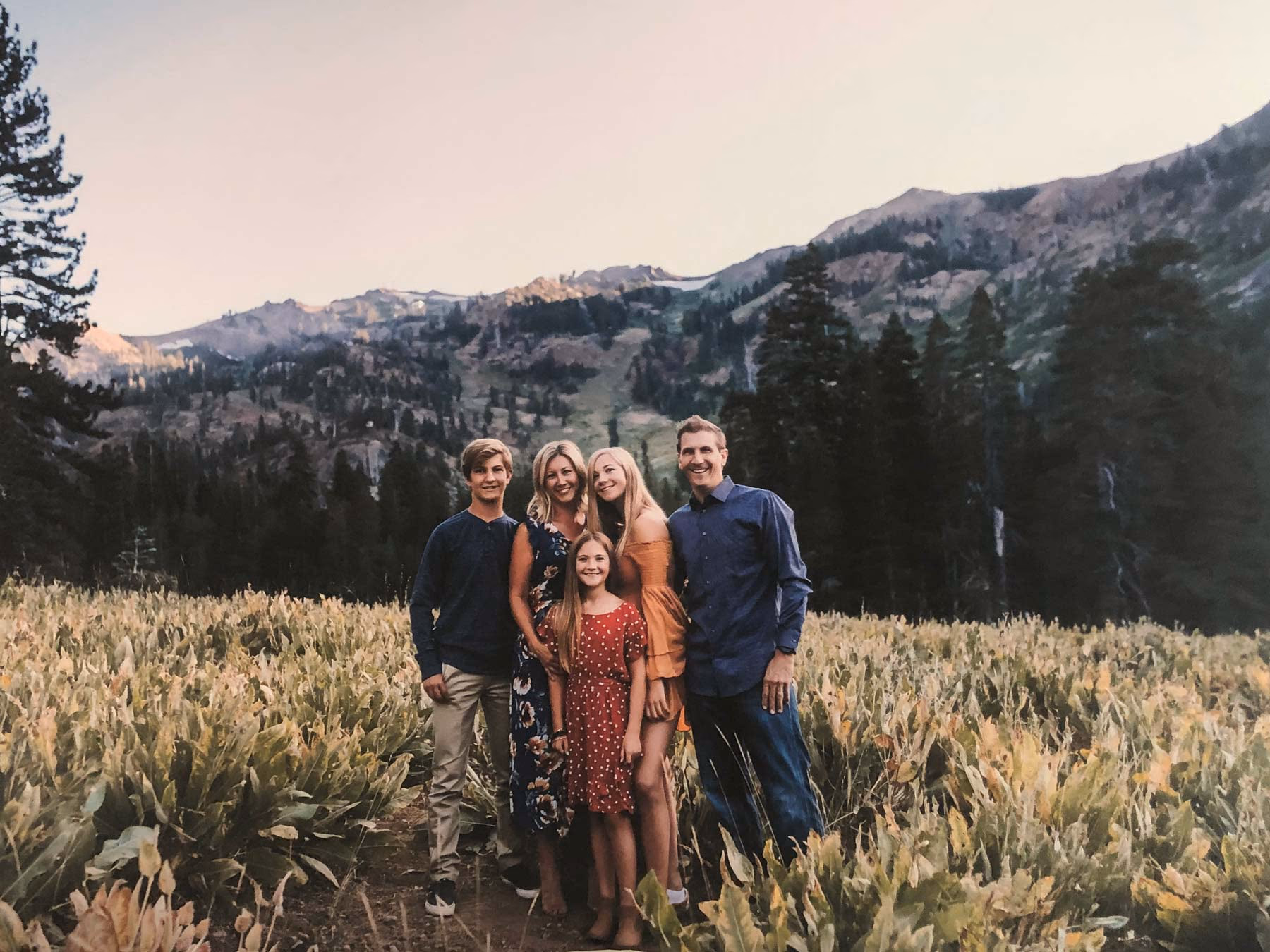 Alicia Cervenka and her family standing together in a mountain meadow